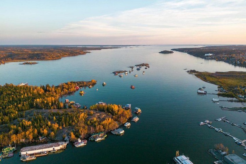 A coastal area with a marina, boats, and a forested peninsula. 1