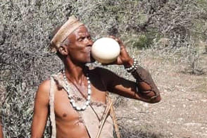 A person in traditional attire holding a white object. 2