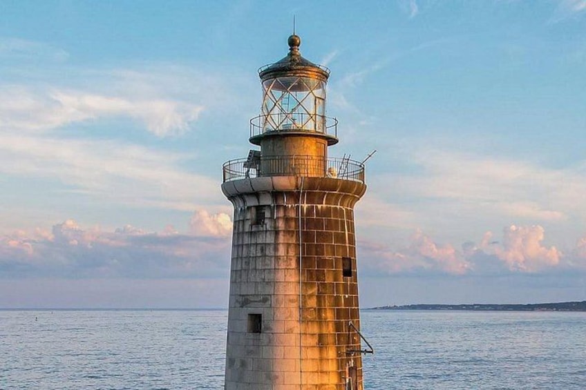 A lighthouse by the sea with a clear sky. 3