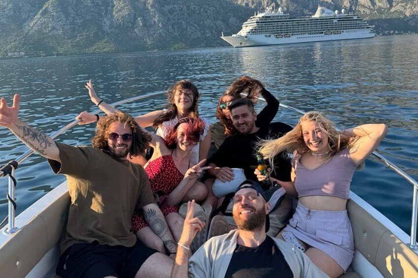 Un groupe de personnes se trouve sur un bateau, avec un navire de croisière en arrière-plan. 3