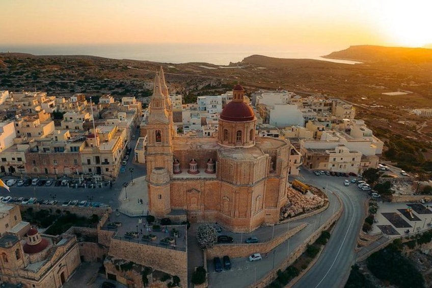 A coastal town with a prominent church, winding roads, and a hilly backdrop. 5