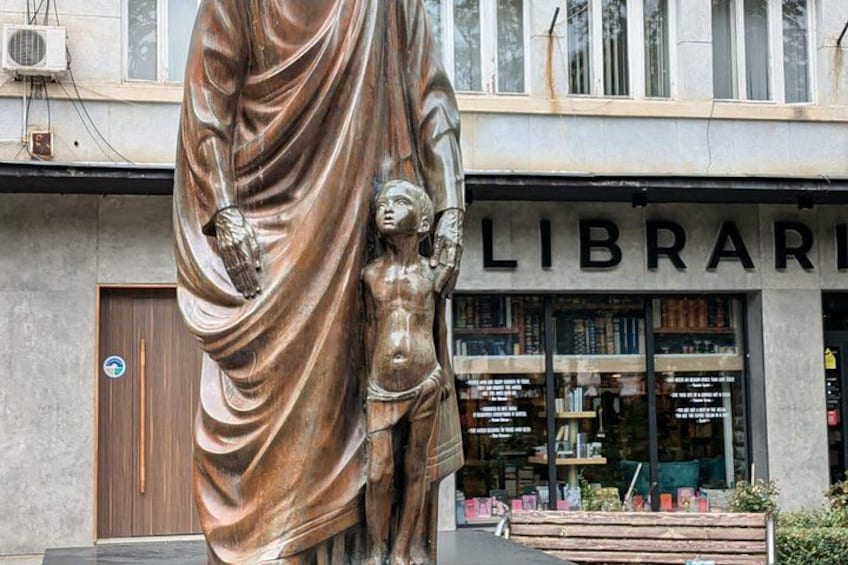 Una estatua de bronce frente a una biblioteca. 4