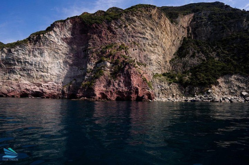 En kystklint med et stejlt fald ned i havet, omgivet af grøn bevækst og klippefyldt terræn. 2