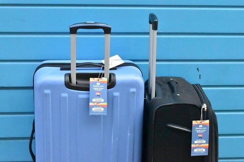 Two suitcases, one blue and one black, with tags attached. 3