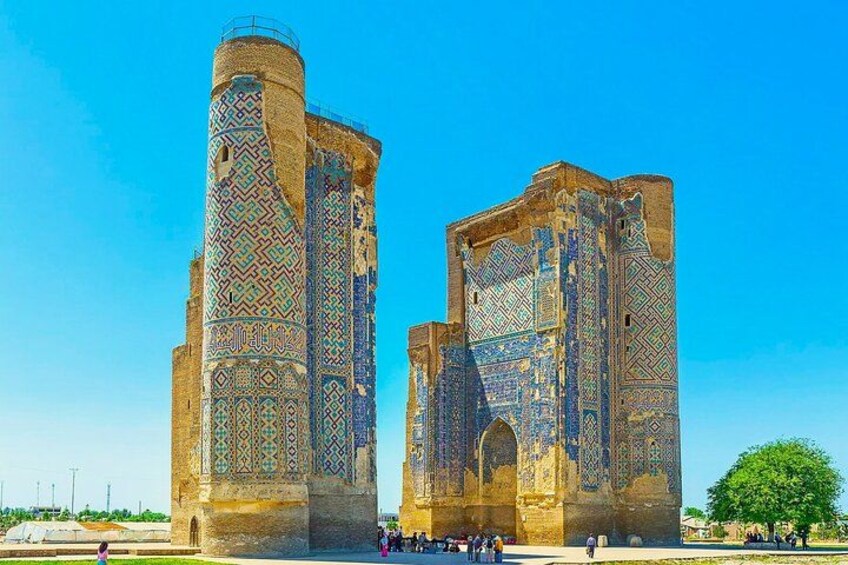 A historic building with intricate tile work and two large towers. 1