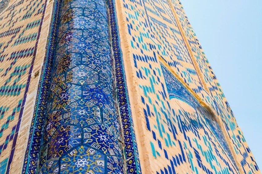 A close-up of a building's facade with intricate blue and beige patterned tiles. 2