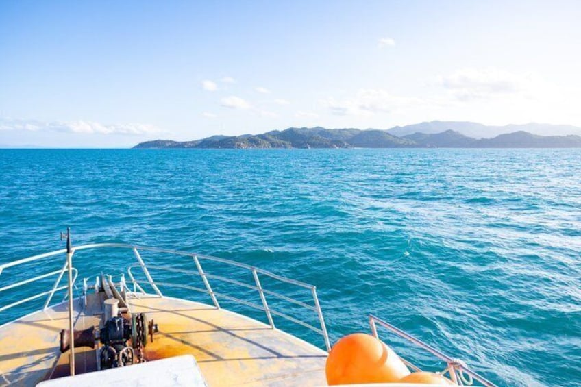 A boat on a calm sea with distant mountains under a clear sky. 2