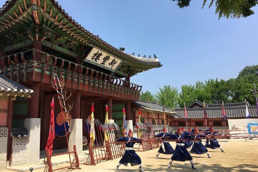 A traditional Korean building with a tiled roof and a sign with Korean characters. 1