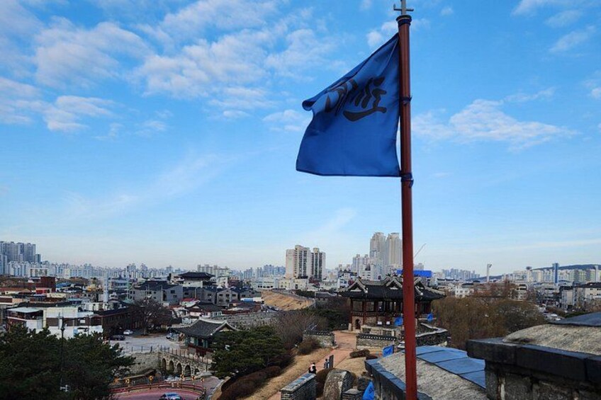 A cityscape with a flag on a pole, buildings, and a clear sky. 2