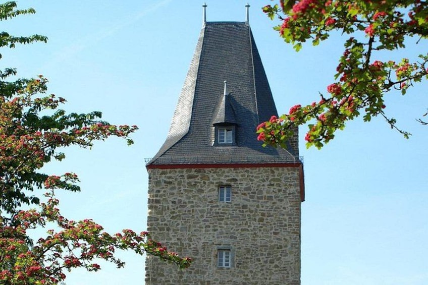 A stone tower with a pointed roof and a small window. 1