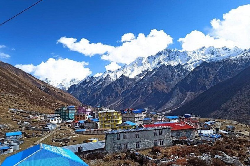 A village with colorful buildings, a mountain range, and snow-capped peaks in the background. 5