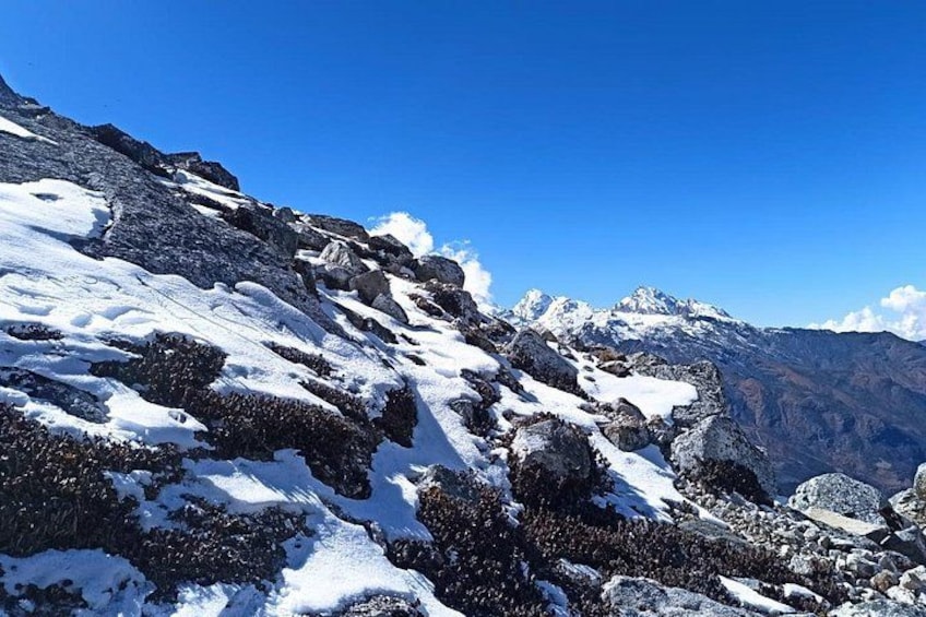 A snow-covered mountain range with rocky terrain and clear blue skies. 2
