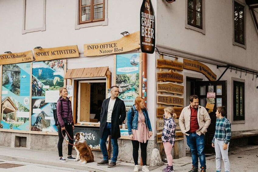 A street with a building displaying signs for activities like hiking and biking, and a sign for a craft beer shop. 3