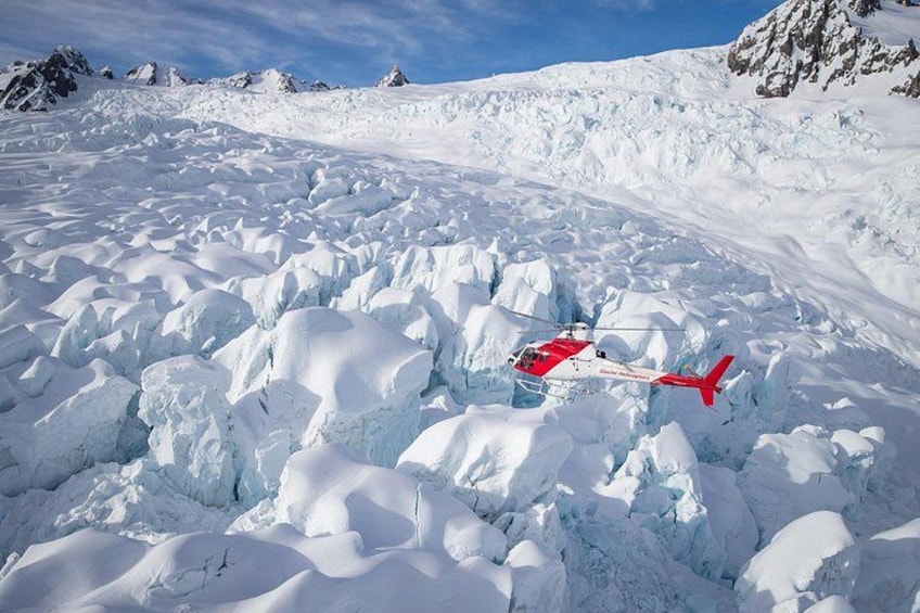 En rød helikopter på et snøklædt bjerg. 5