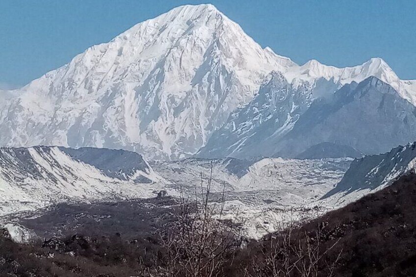 Una cordillera nevada con un pico destacado y un valle en primer plano. 2