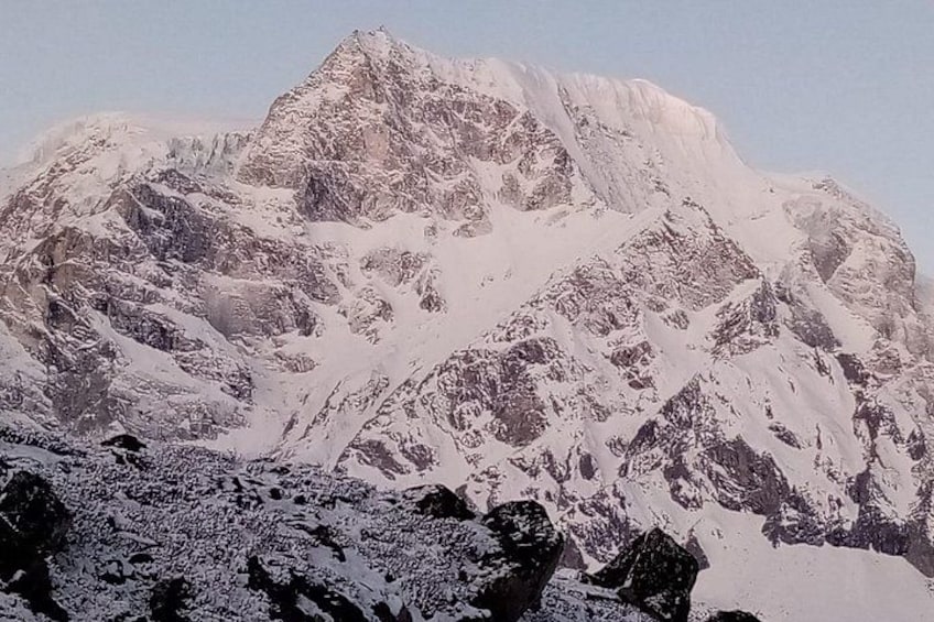 Ett snötäckt bergstopp med ett kargt landskap och framträdande klippformationer. 5