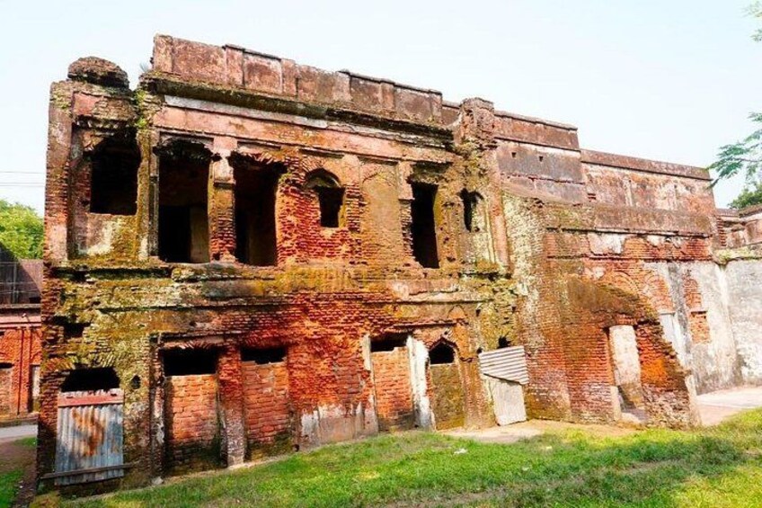 Un edificio antiguo y desgastado, con ladrillo a la vista y ventanas de arco. 2