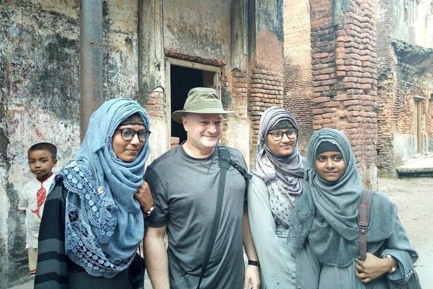 Un grupo de personas frente a un edificio antiguo de ladrillo con una puerta. 4