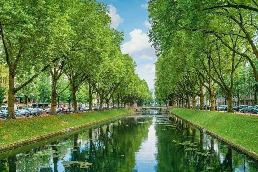 Un canal bordé d’arbres, un pont et des voitures garées. 3