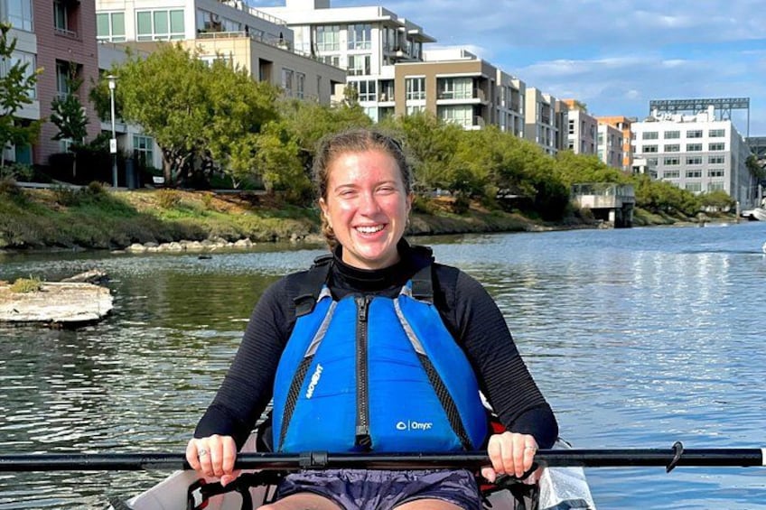 Una persona en kayak en un río, con edificios al fondo. 5