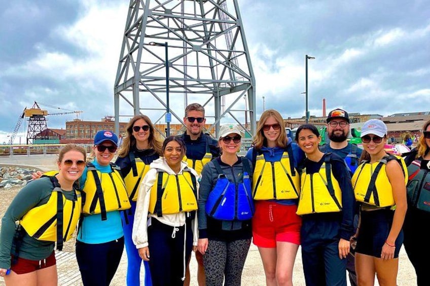 Un grupo de personas con chalecos salvavidas de pie frente a una estructura metálica. 4