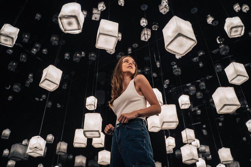 A person standing in a room with hanging light fixtures. 4