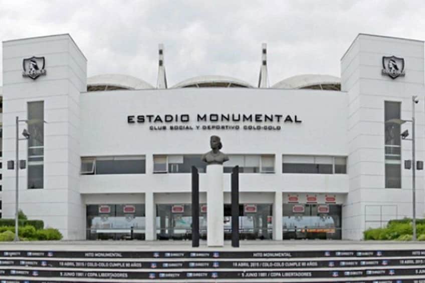 A white stadium with a statue in front, named 'Estadio Monumental.' 1