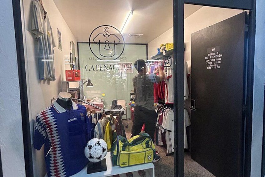 A clothing store with a mannequin, racks of clothes, and a door with a sign. 3