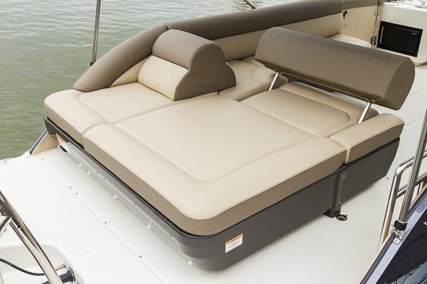A boat with a cushioned seating area and a canopy. 2
