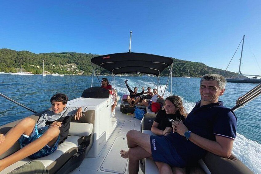 A boat with people on board, water, and a distant bridge. 5