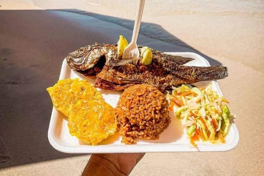 A meal with fried fish, rice, coleslaw, and plantain chips on a tray. 5