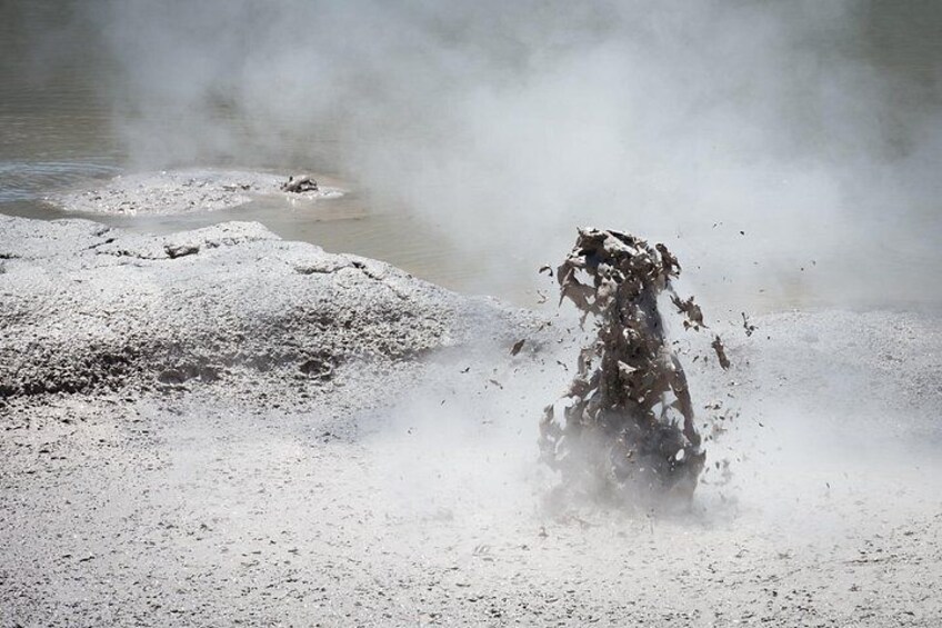A geyser erupting with steam and water. 2