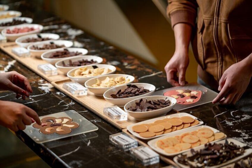 Une personne qui décore des biscuits avec des pépites de chocolat et d'autres garnitures. 1