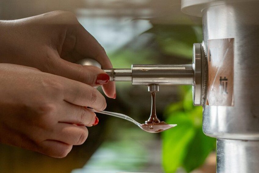 A hand holding a spoon under a metal tap, drawing water. 3