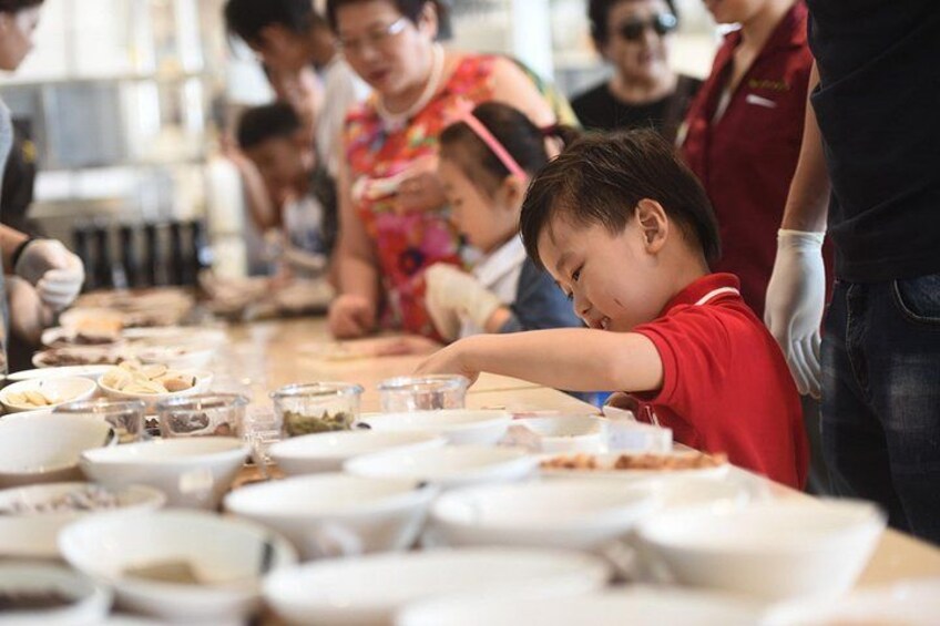 A group of people sitting at a long table with various dishes. 4
