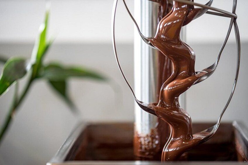 A glass container with a wavy liquid, possibly chocolate, being poured. 2