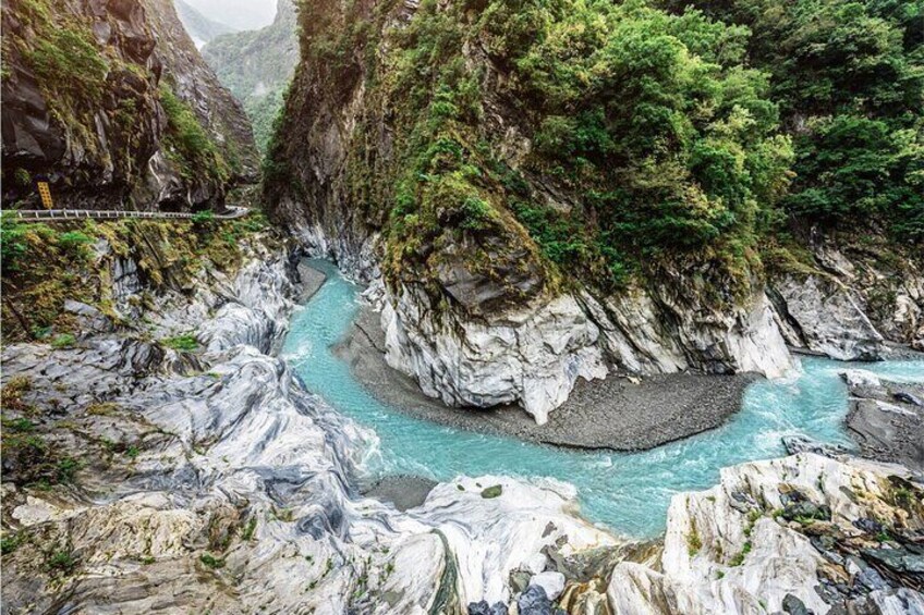 A river winding through a rocky canyon with lush greenery on the sides. 1