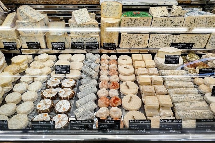 A cheese display with various types of cheese in a refrigerated case. 2