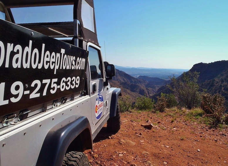 Un vehículo todoterreno blanco con un letrero negro que anuncia Colorado Jeep Tours. 5