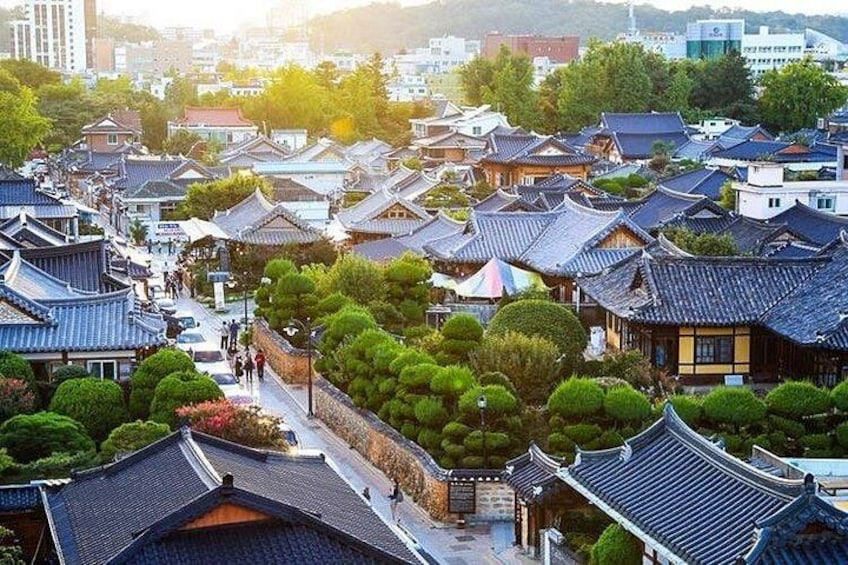 A traditional Korean village with tiled roofs, wooden buildings, and well-maintained gardens. 1