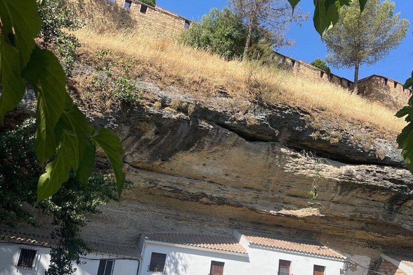 Un acantilado rocoso con edificios en su base. 5
