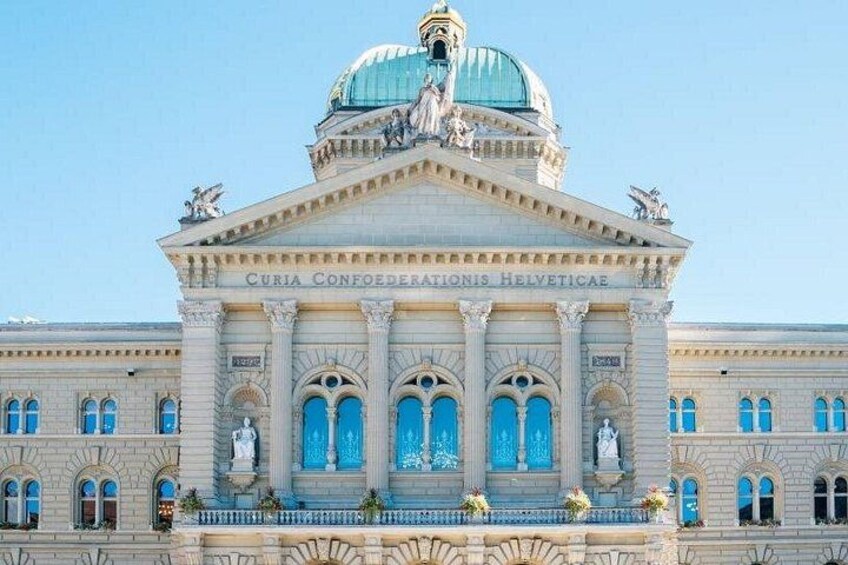 A grand building with a dome and columns, featuring the inscription 'Curia Confœderationis Helveticae'. 5