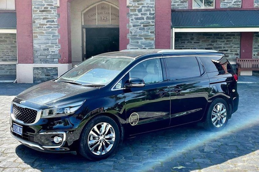 Ein schwarzer SUV vor einem Gebäude mit einer steinernen Fassade und einer Beschilderung mit der Nummer 125. 3