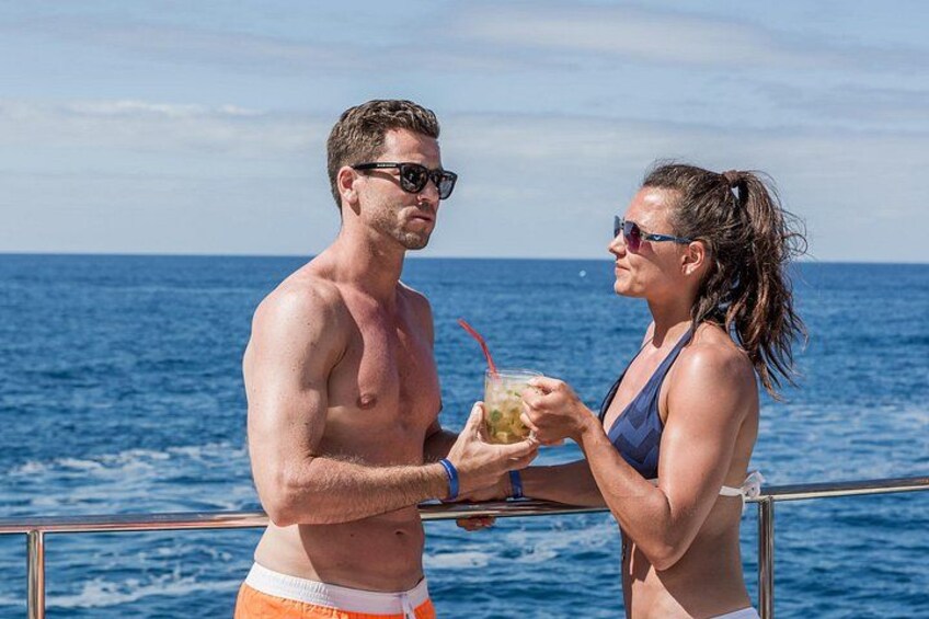 Een man en een vrouw op een boot, die een drankje met rietje vasthouden. 5