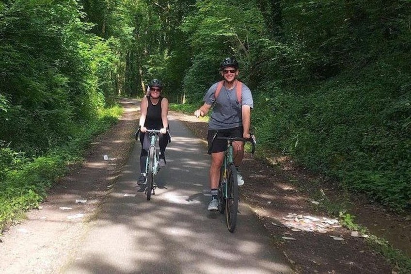 Deux cyclistes sur une piste asphaltée, entourés d’une végétation luxuriante. 5