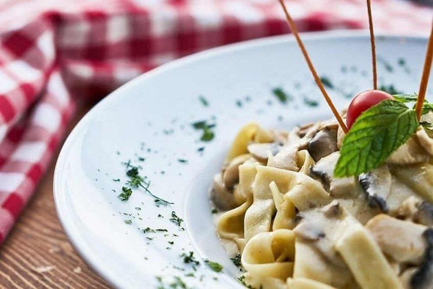 Een bord pasta, versierd met een kerstomaatje en een muntblaadje. 5