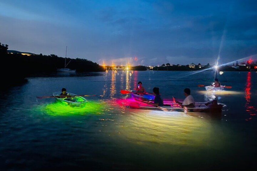People in a boat on a river at night with colorful lights. 2