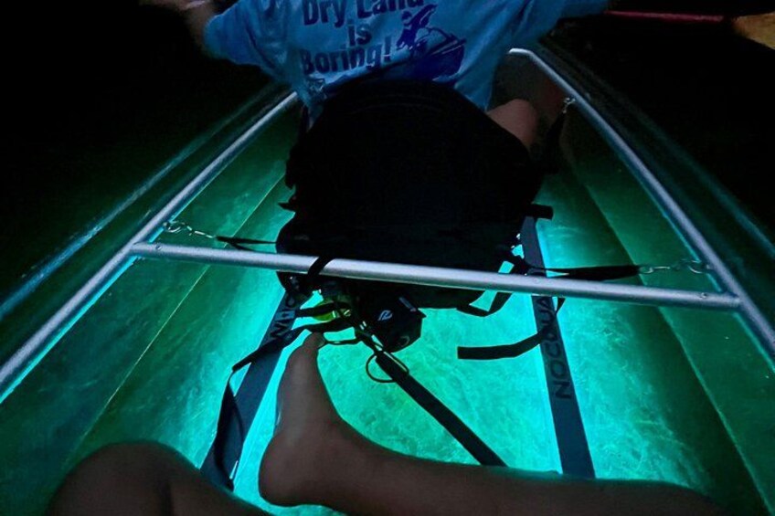 A person lying on a kayak with a metal frame, wearing a blue shirt and black shorts. 3