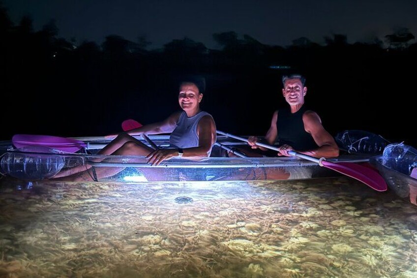 Two people in a small boat on a body of water at night. 3
