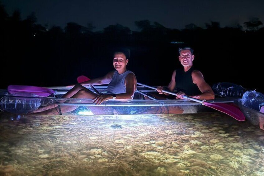 Two people in a small boat on a body of water at night. 3